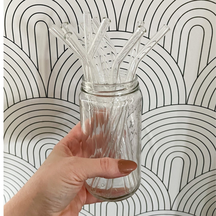Jar with clear bent reusable glass drinking straws.