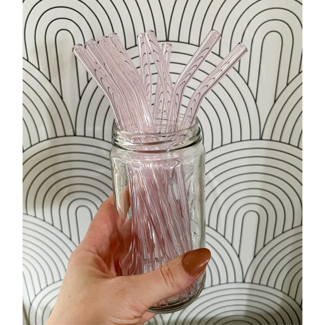 Jar with pink bent reusable glass drinking straws